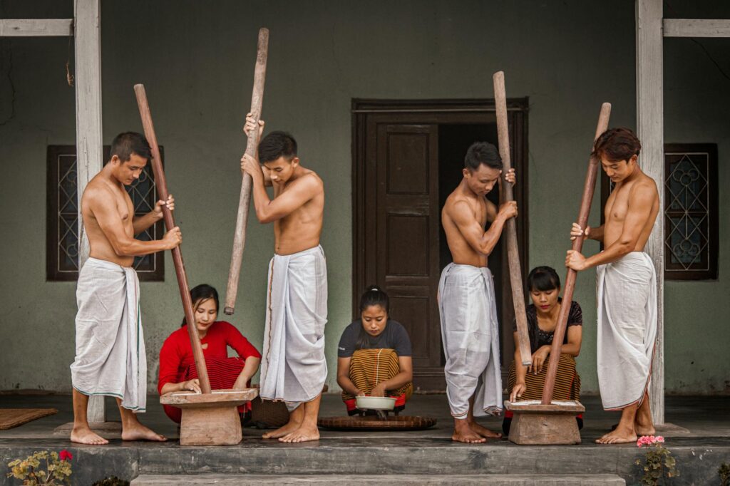 Cultural depiction of traditional rice preparation by group collaboration.